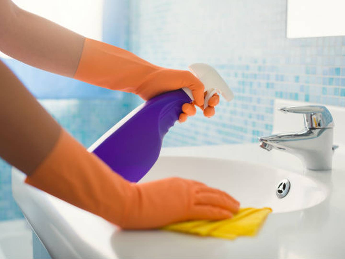 pessoa limpando pia do banheiro